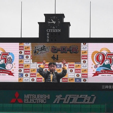 阪神甲子園球場95周年記念グランドウォークに参加させていただいた時の写真です。息子８歳、スコアボードに映っています。
